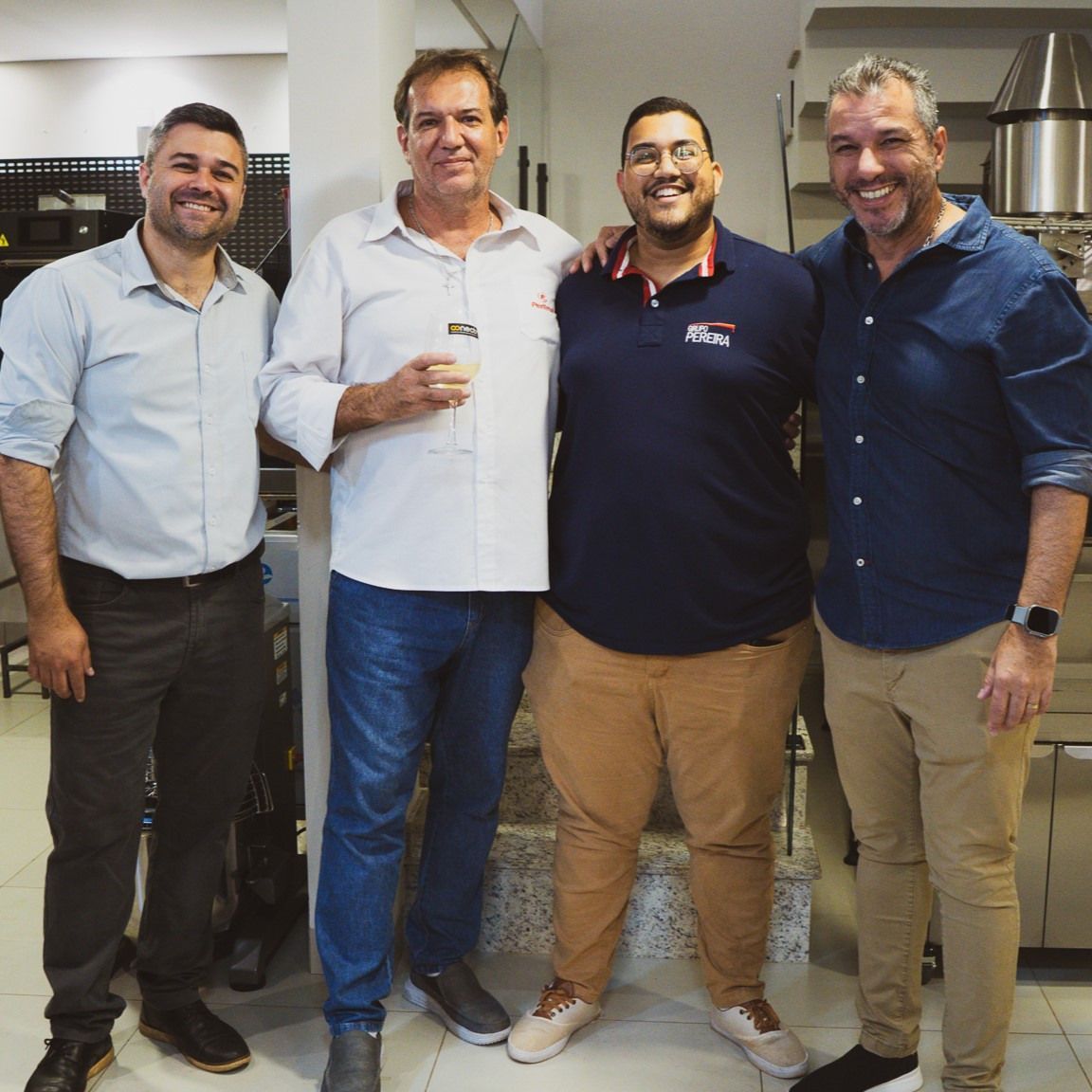 Um grupo de homens posando para uma foto, um deles vestindo uma camisa que diz lacoste