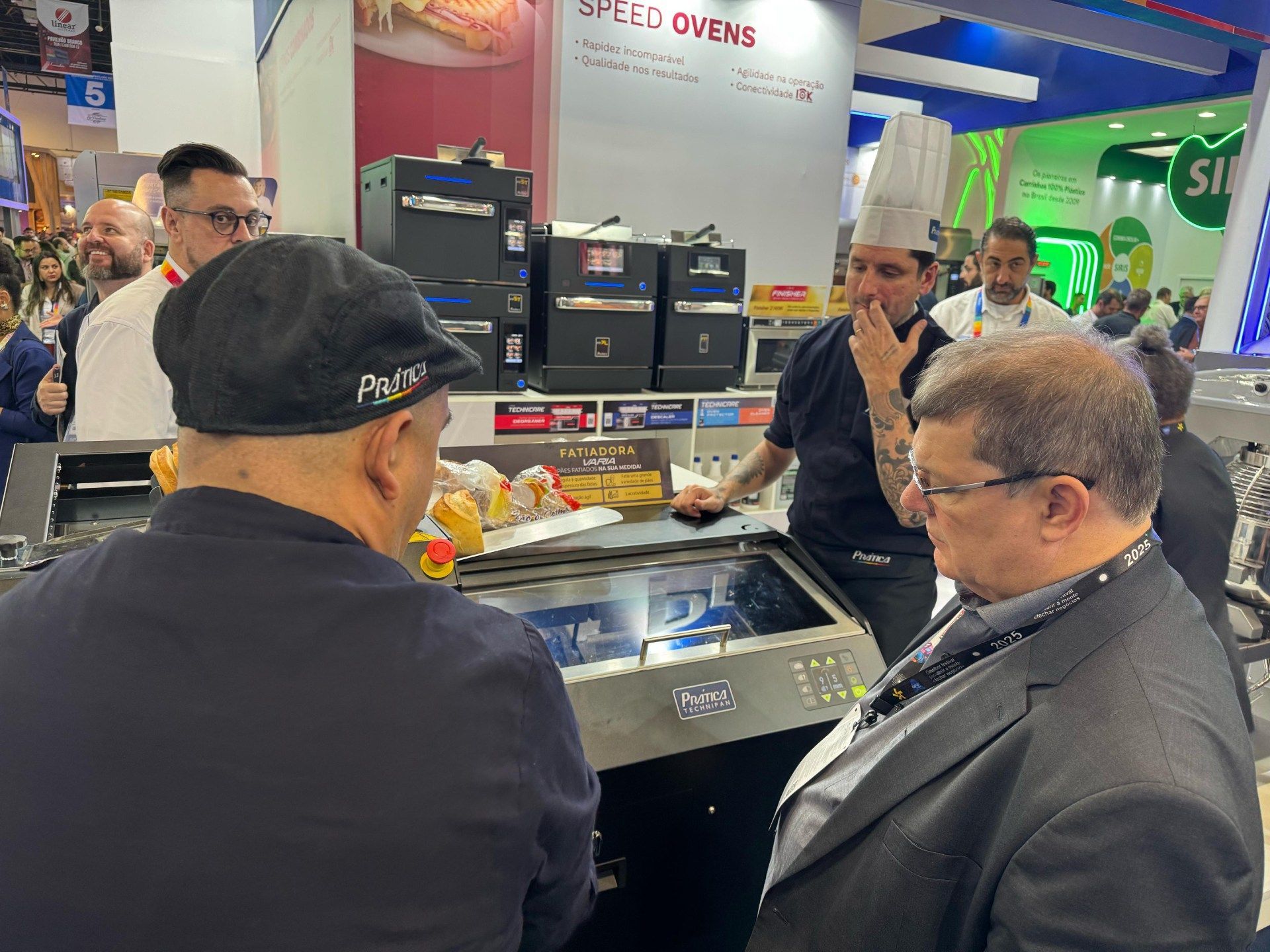 Um grupo de homens está em volta de uma mesa conversando entre si.