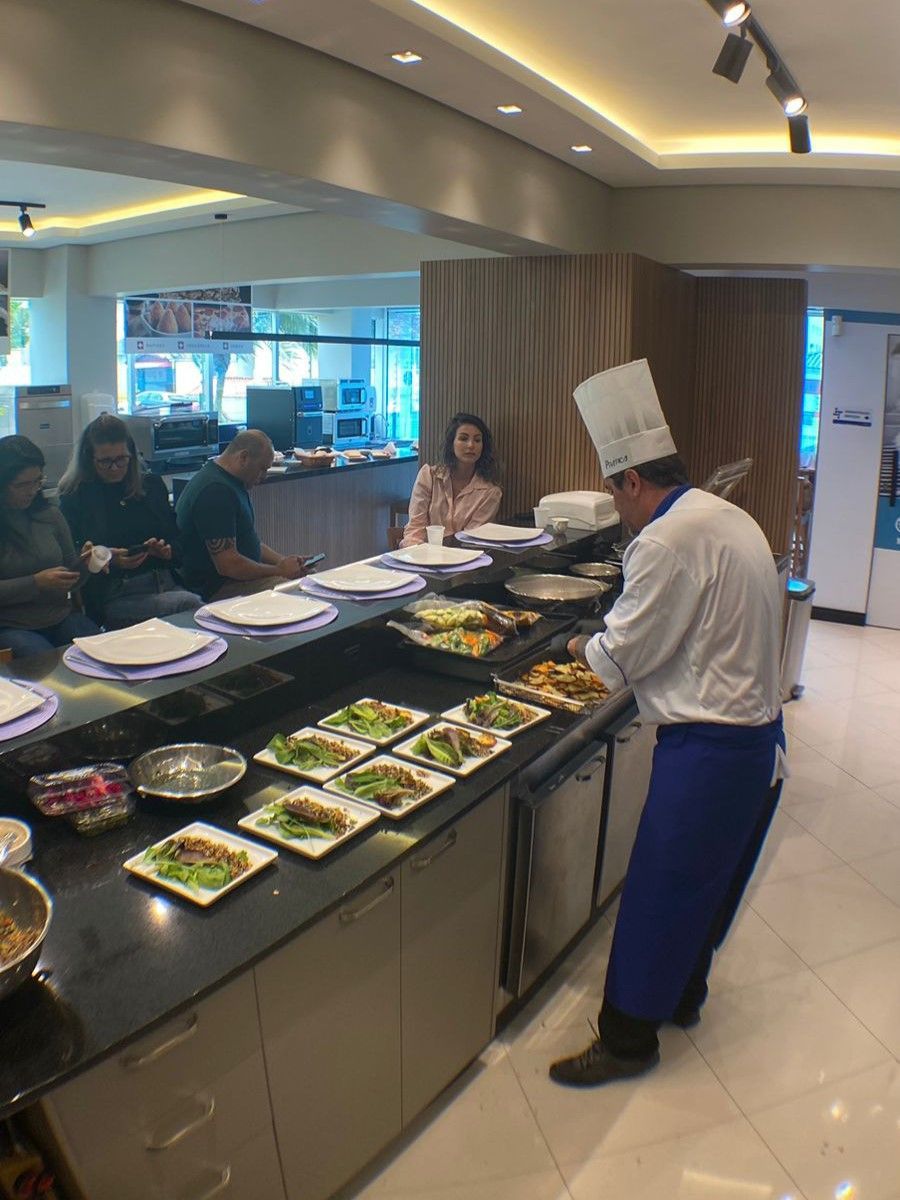 Um chef está preparando comida em uma fila de bufê