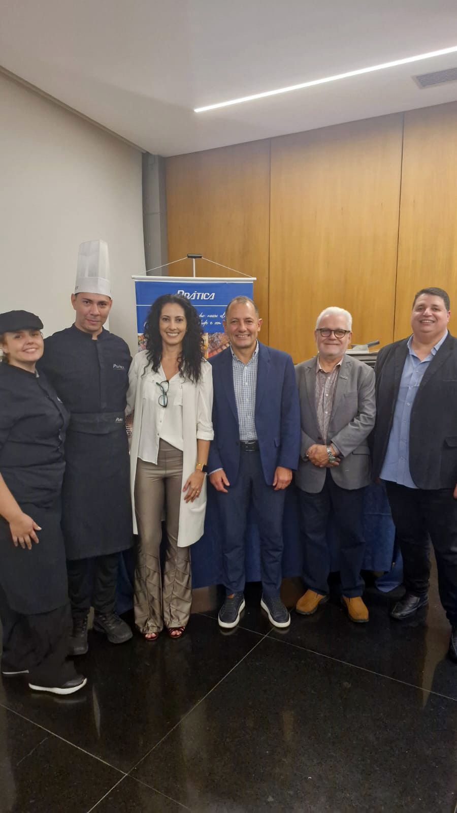 Um grupo de pessoas está posando para uma foto em uma sala.