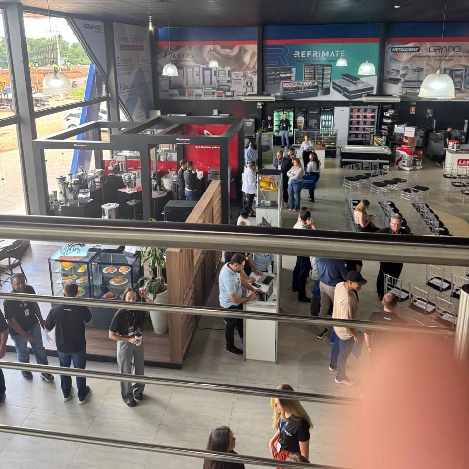 Um grupo de pessoas está reunido em uma grande sala com uma placa que diz 'mcdonald's' nela