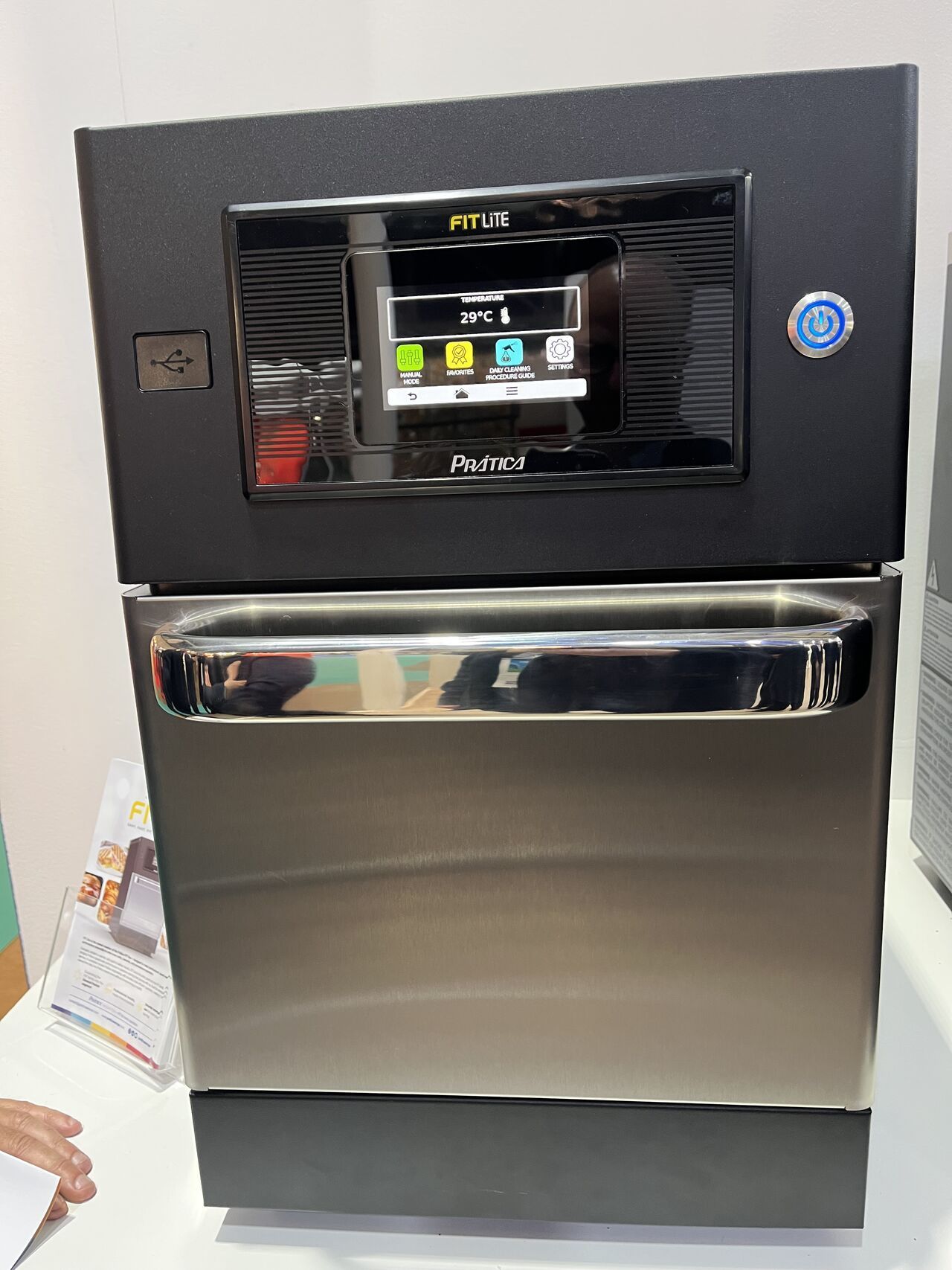 Forno comercial preto e aço inoxidável com painel de controle com tela sensível ao toque.