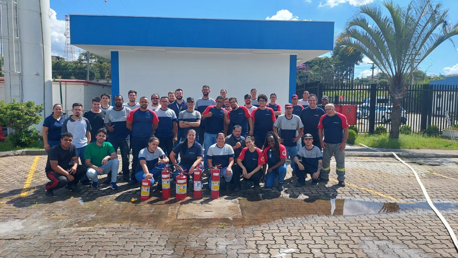 Um grupo de pessoas está posando para uma foto em frente a um prédio.