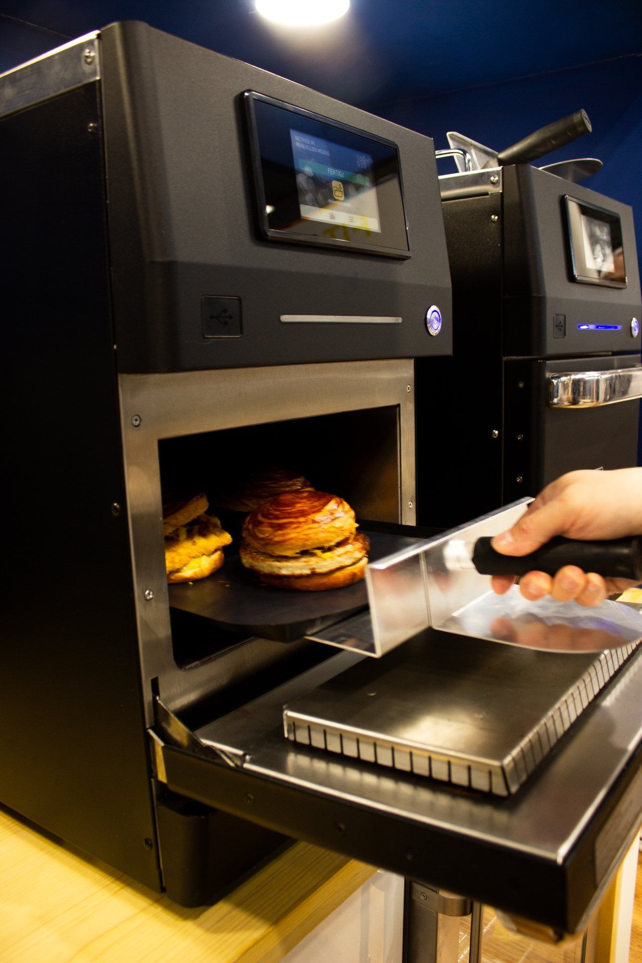 Uma pessoa está tirando um hambúrguer de uma máquina