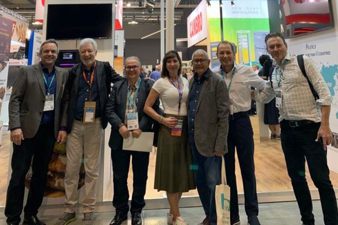 Um grupo de pessoas está posando para uma foto em uma convenção.