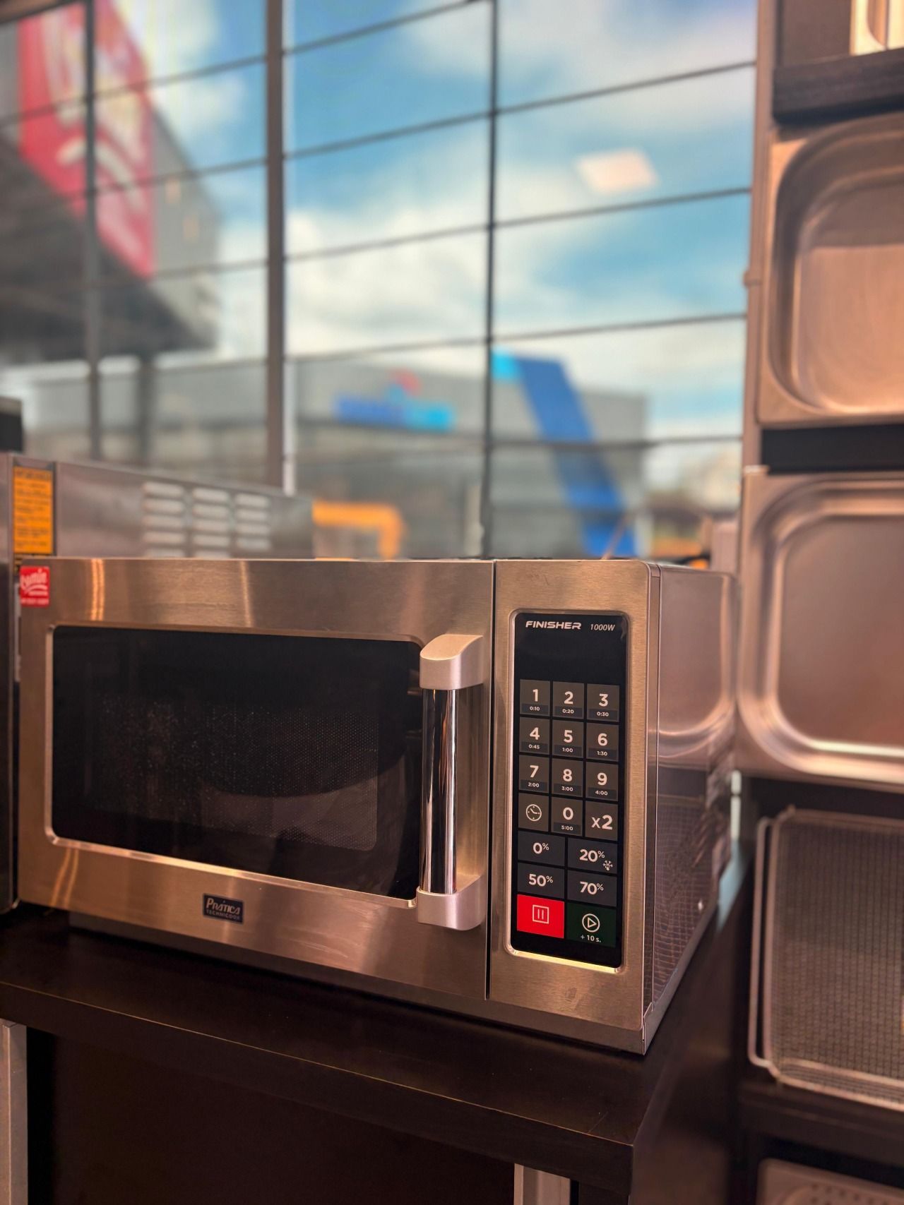 Um forno de micro-ondas de aço inoxidável está sobre uma mesa