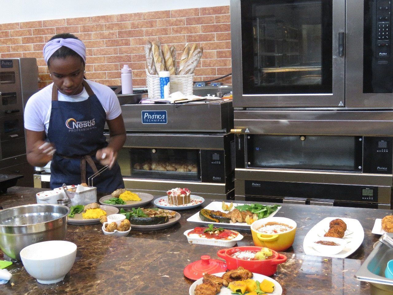 Uma mulher usando um avental que diz coroa está preparando comida em uma cozinha