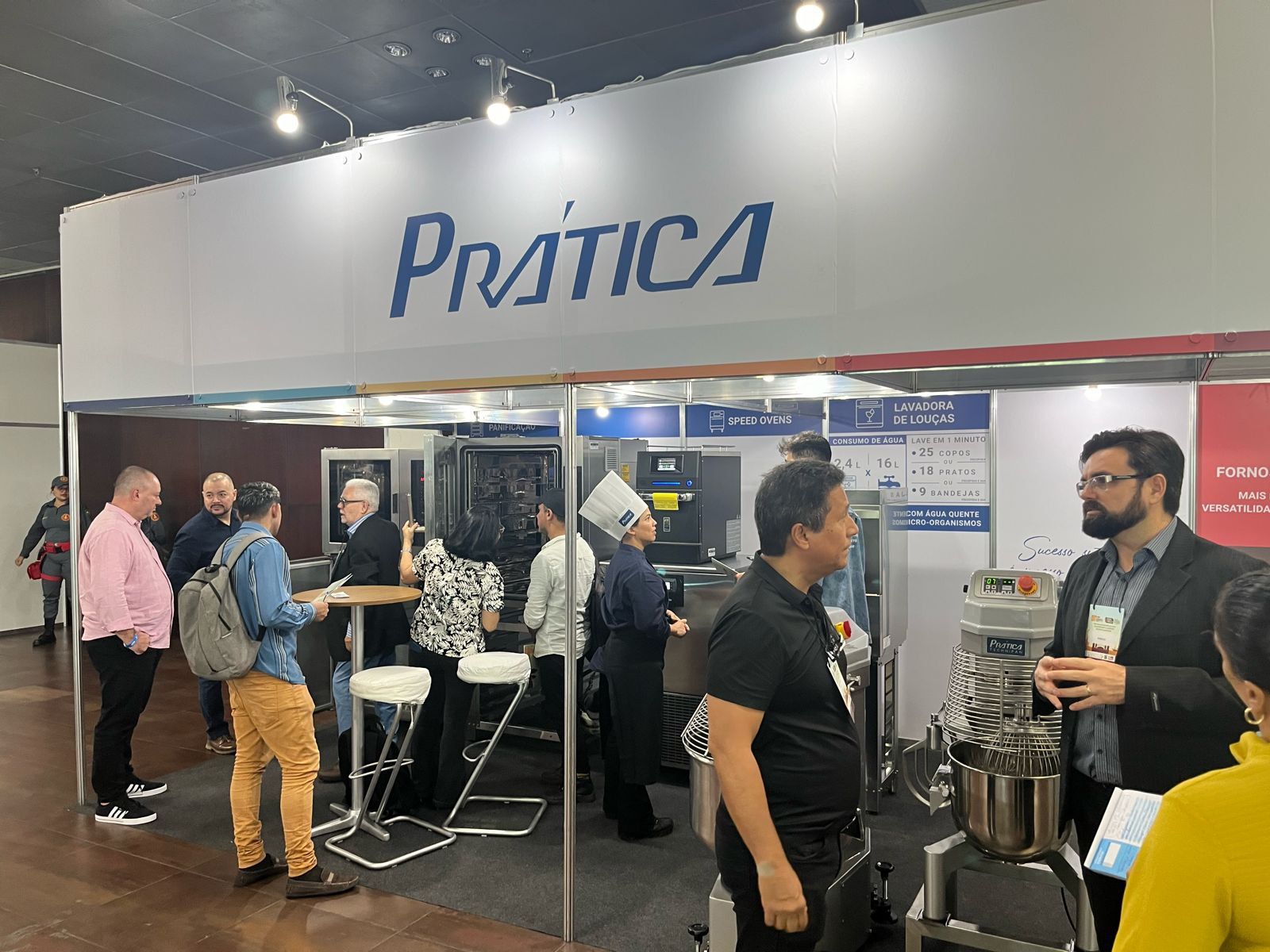 Um grupo de pessoas está em volta de um estande em uma convenção.