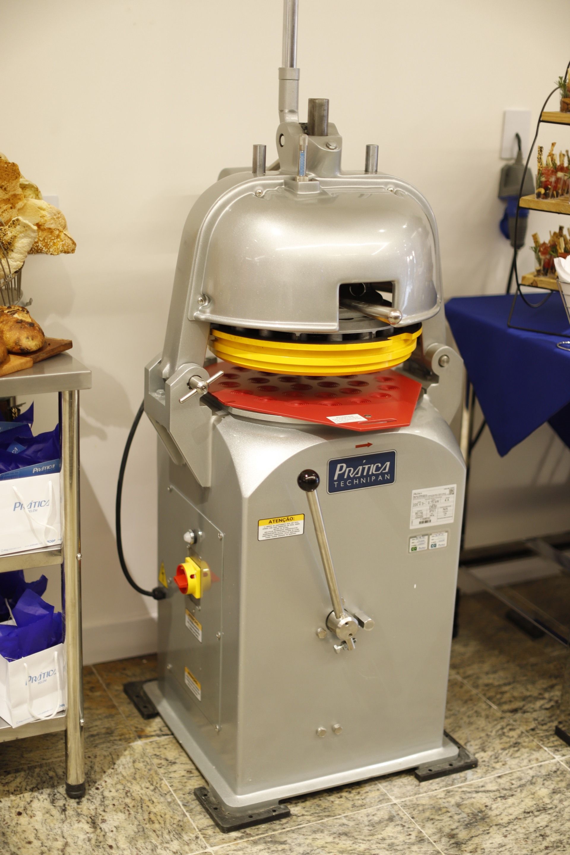 Misturador de massa comercial prateado em ambiente de padaria.