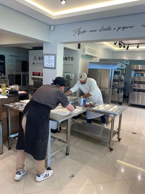 Dois homens estão trabalhando em uma mesa na cozinha.