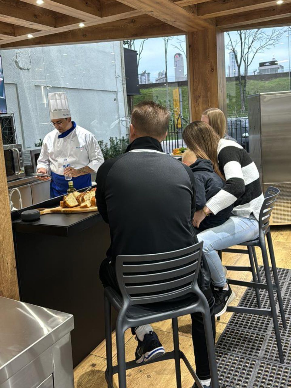 Um grupo de pessoas está sentado em um balcão enquanto um chef prepara comida.