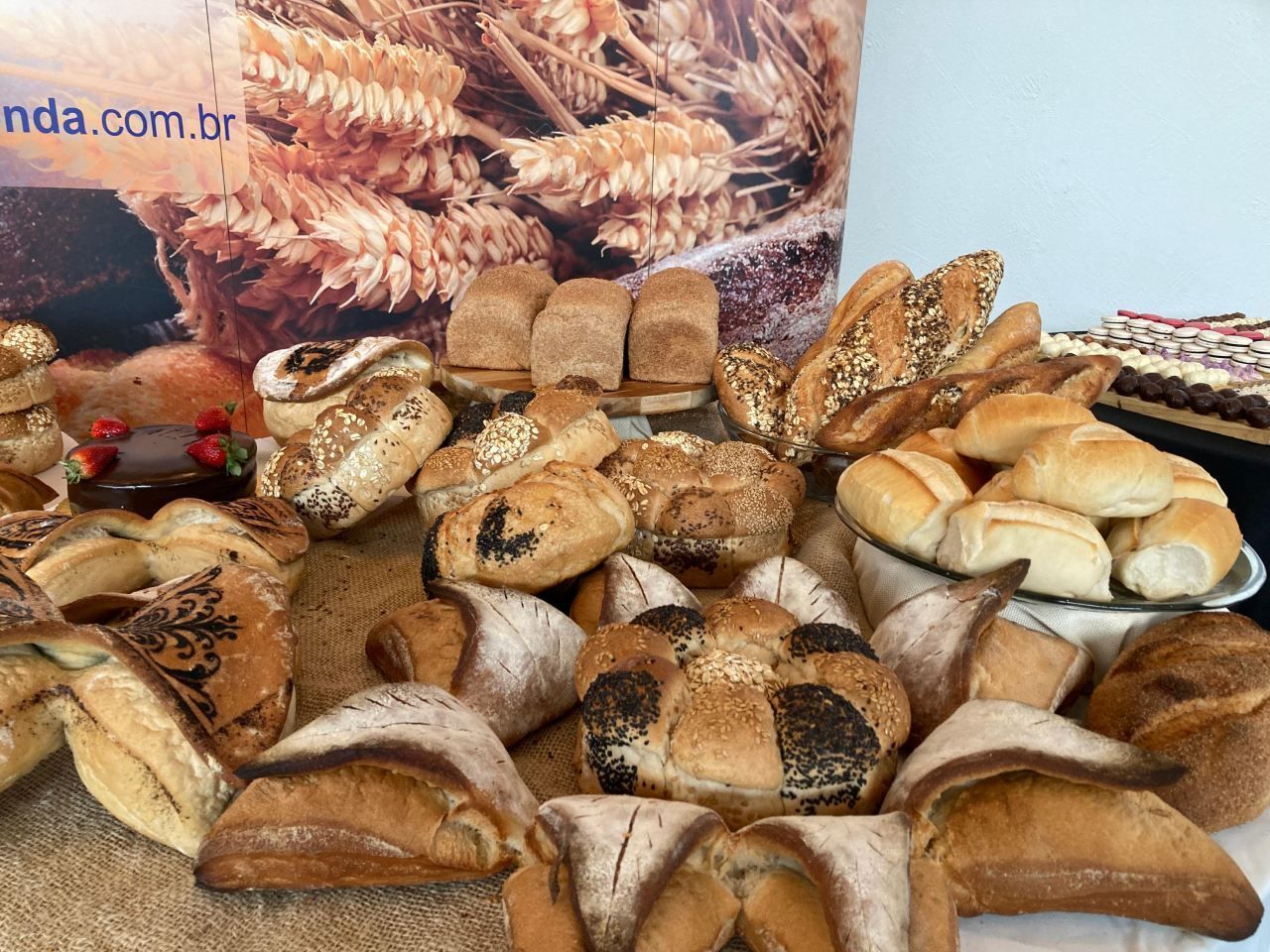 Um monte de diferentes tipos de pão estão sobre uma mesa