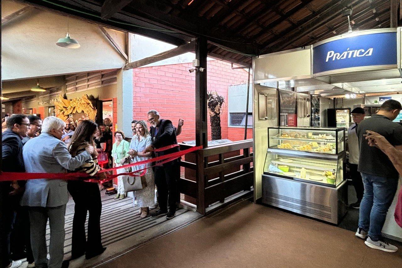 Um grupo de pessoas está em frente a uma padaria.