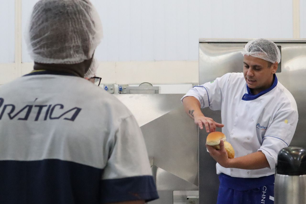 Um homem vestindo uma camisa de treino está de pé ao lado de outro homem