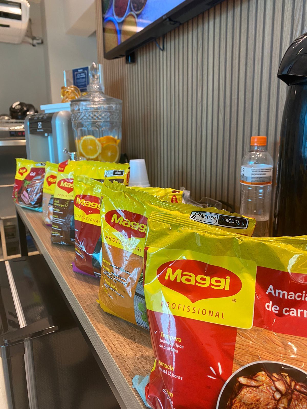 Uma fileira de sacos de macarrão maggi estão sobre uma mesa de madeira.