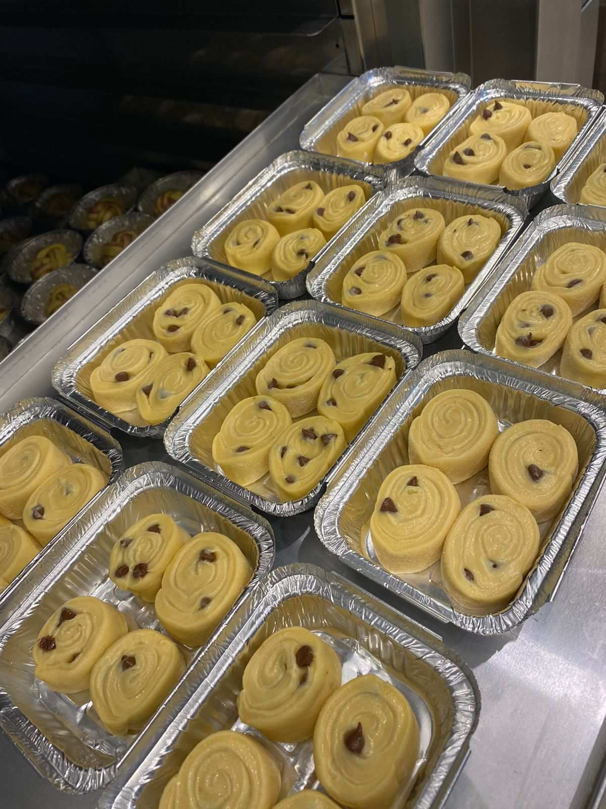 Várias bandejas de comida estão sobre uma mesa.