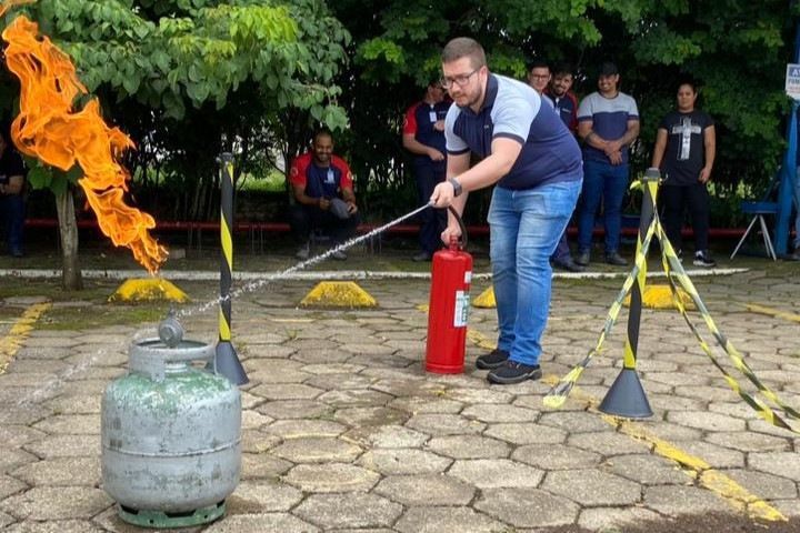 Um homem está usando um extintor de incêndio para apagar um incêndio.