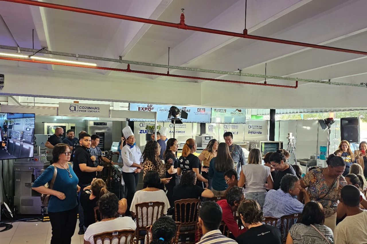 Um grande grupo de pessoas está reunido em uma sala.