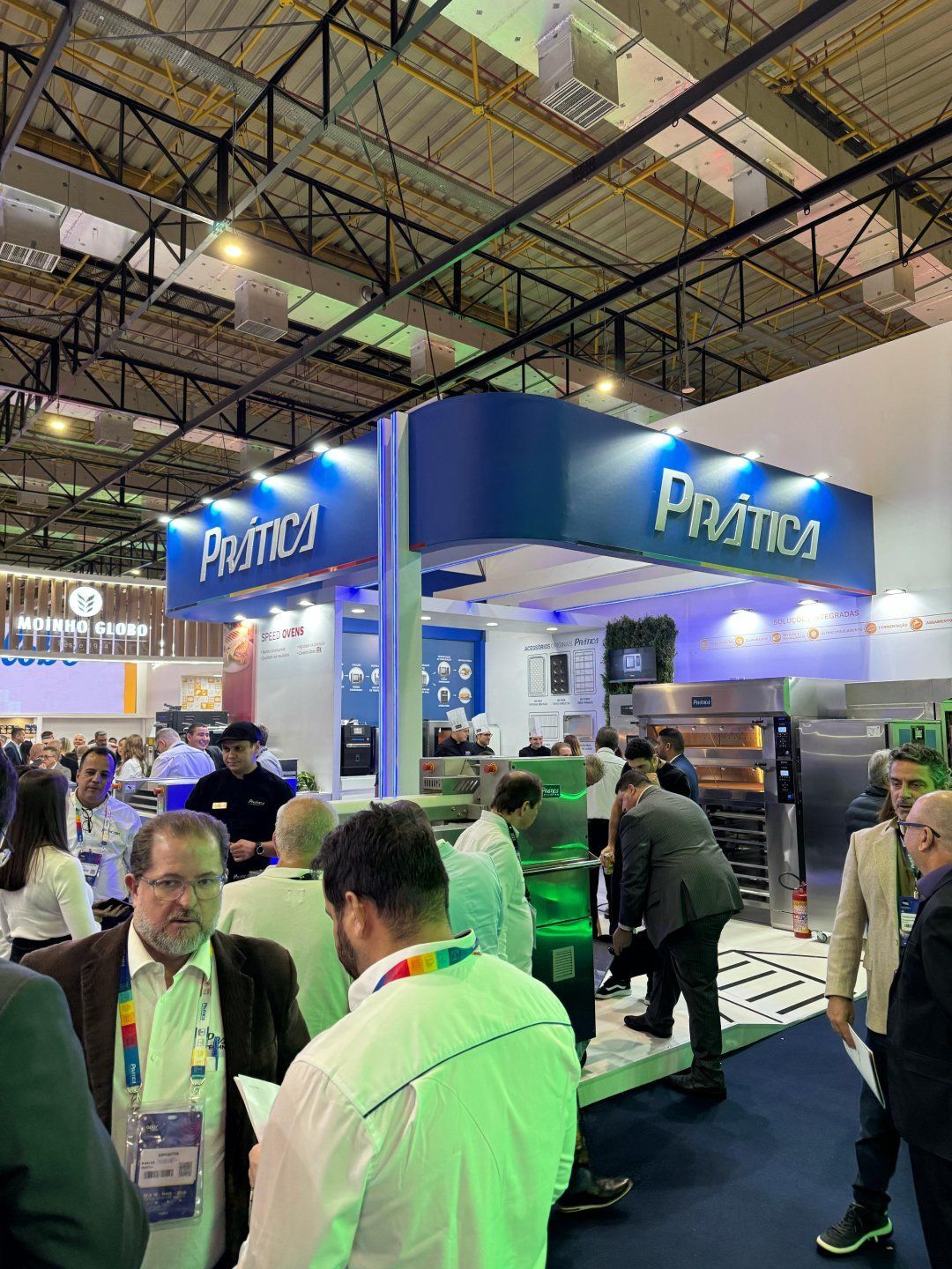 Um grupo de pessoas está em volta de um estande em uma convenção.