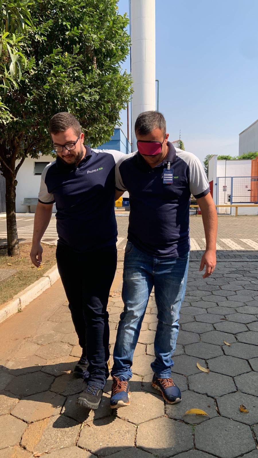 Um homem está ajudando outro homem a andar pela calçada.