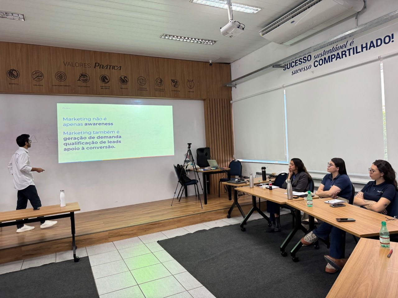 Uma pessoa faz uma apresentação em frente a uma tela de projeção