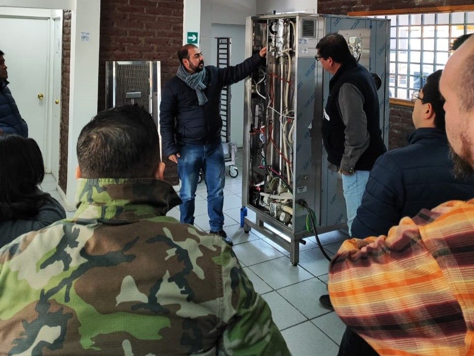 Um homem com uma jaqueta camuflada está conversando com um grupo de pessoas