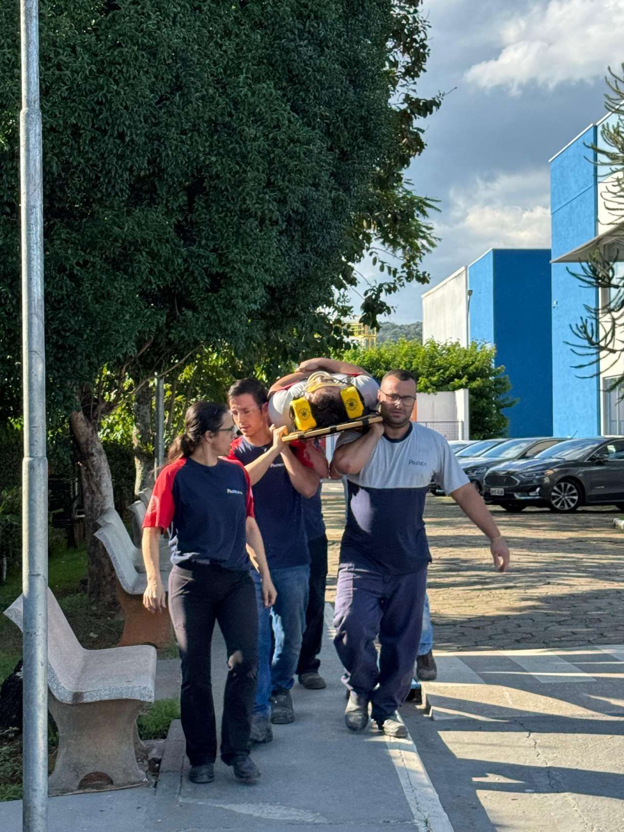 Um grupo de pessoas está carregando uma pessoa em uma maca.