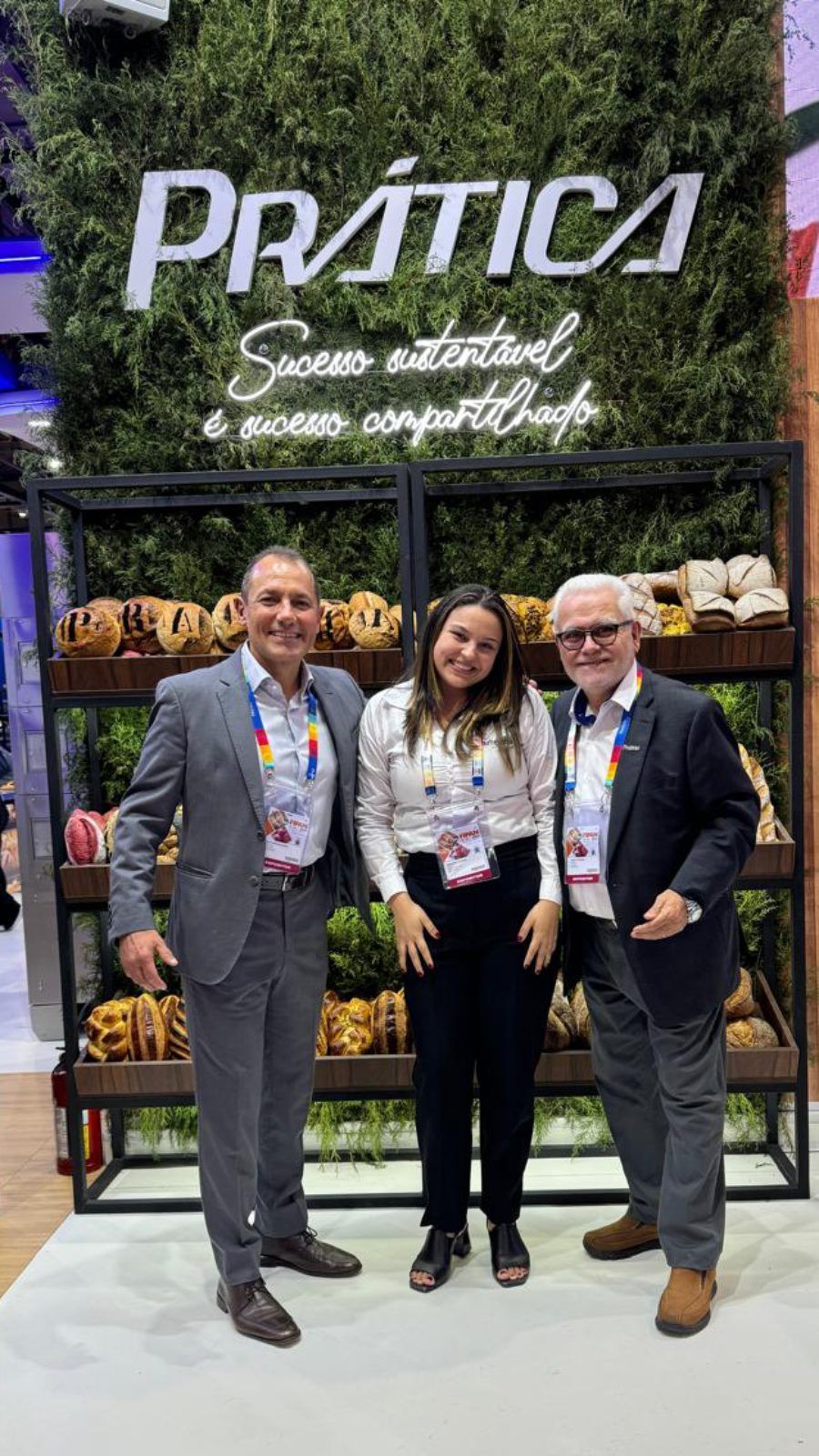Um grupo de pessoas está posando para uma foto em frente a uma placa.