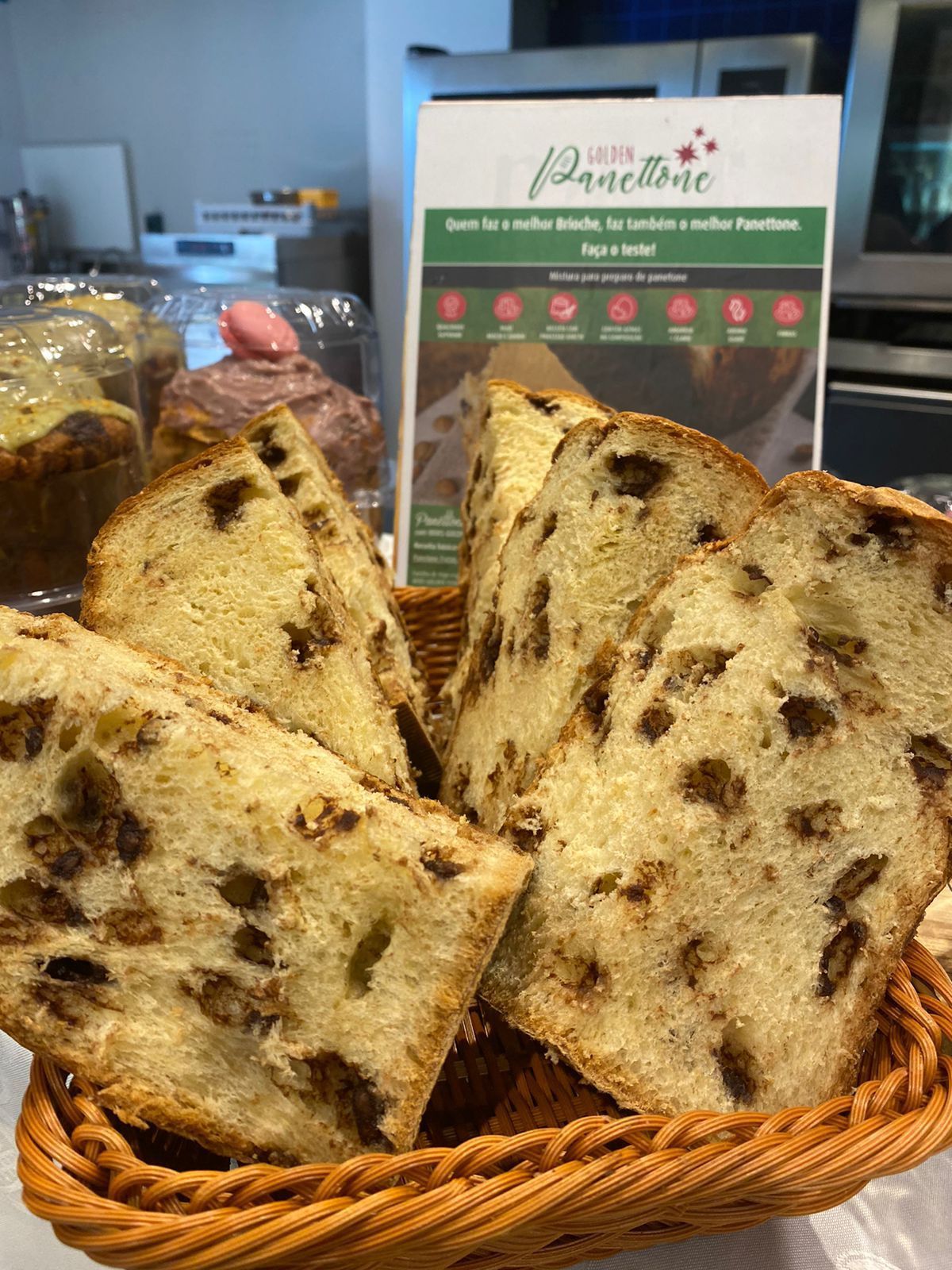 Uma cesta de pães com passas está sobre uma mesa.