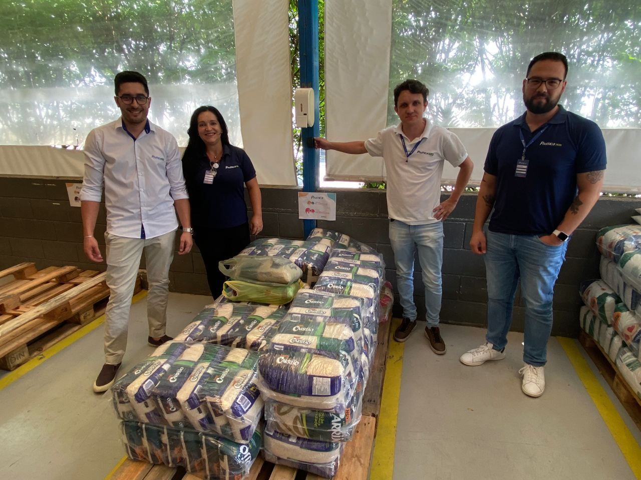 Um grupo de pessoas está em pé em frente a um palete de papel higiênico.