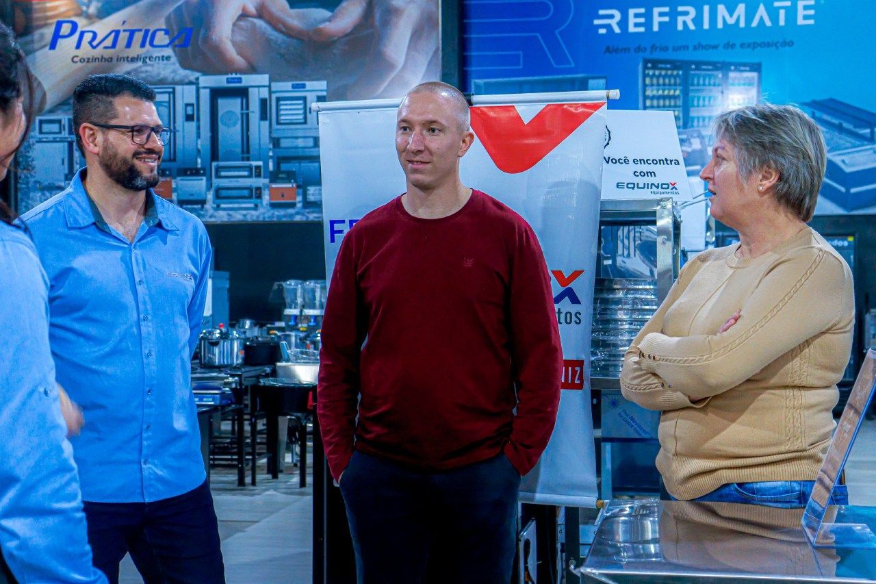 Um grupo de pessoas está em uma sala conversando entre si.