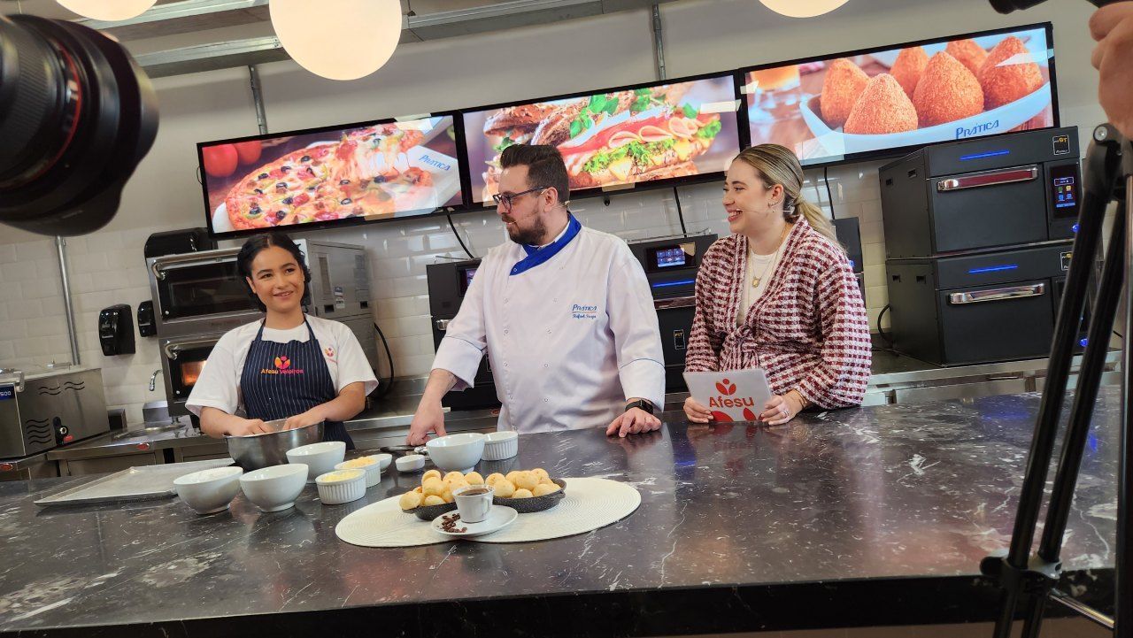 Um homem e duas mulheres estão sentados à mesa na cozinha.
