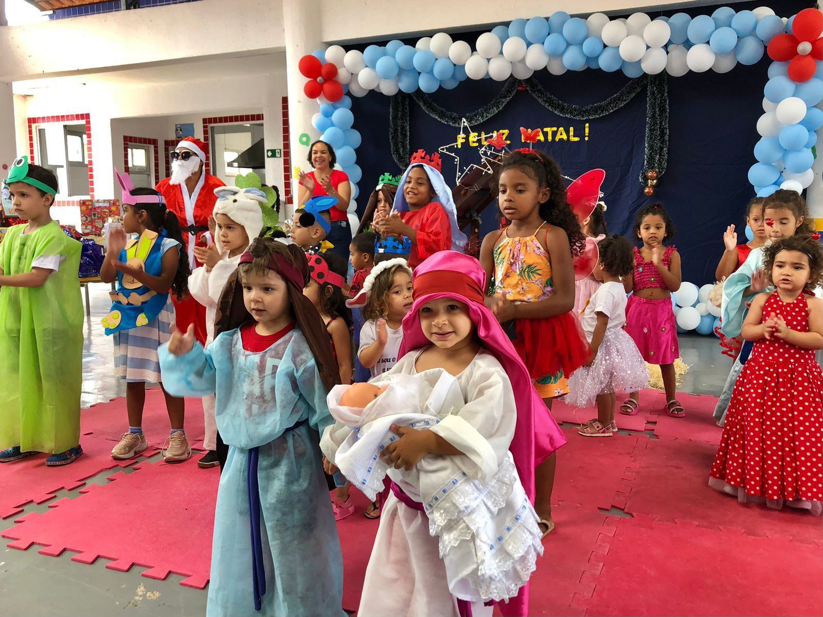 Um grupo de crianças fantasiadas estão dançando em um palco.