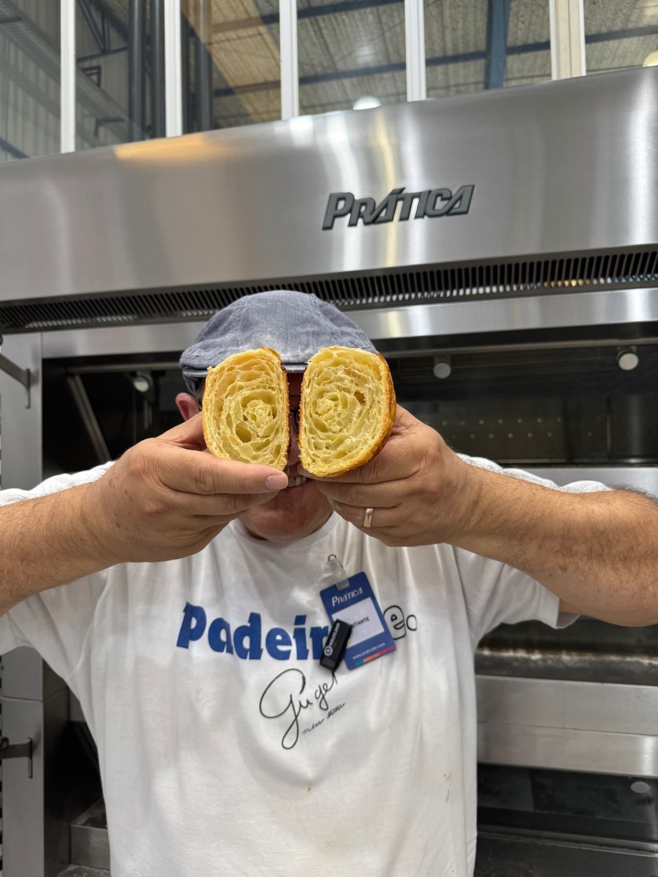 Um homem está segurando um pedaço de pão na frente do rosto.