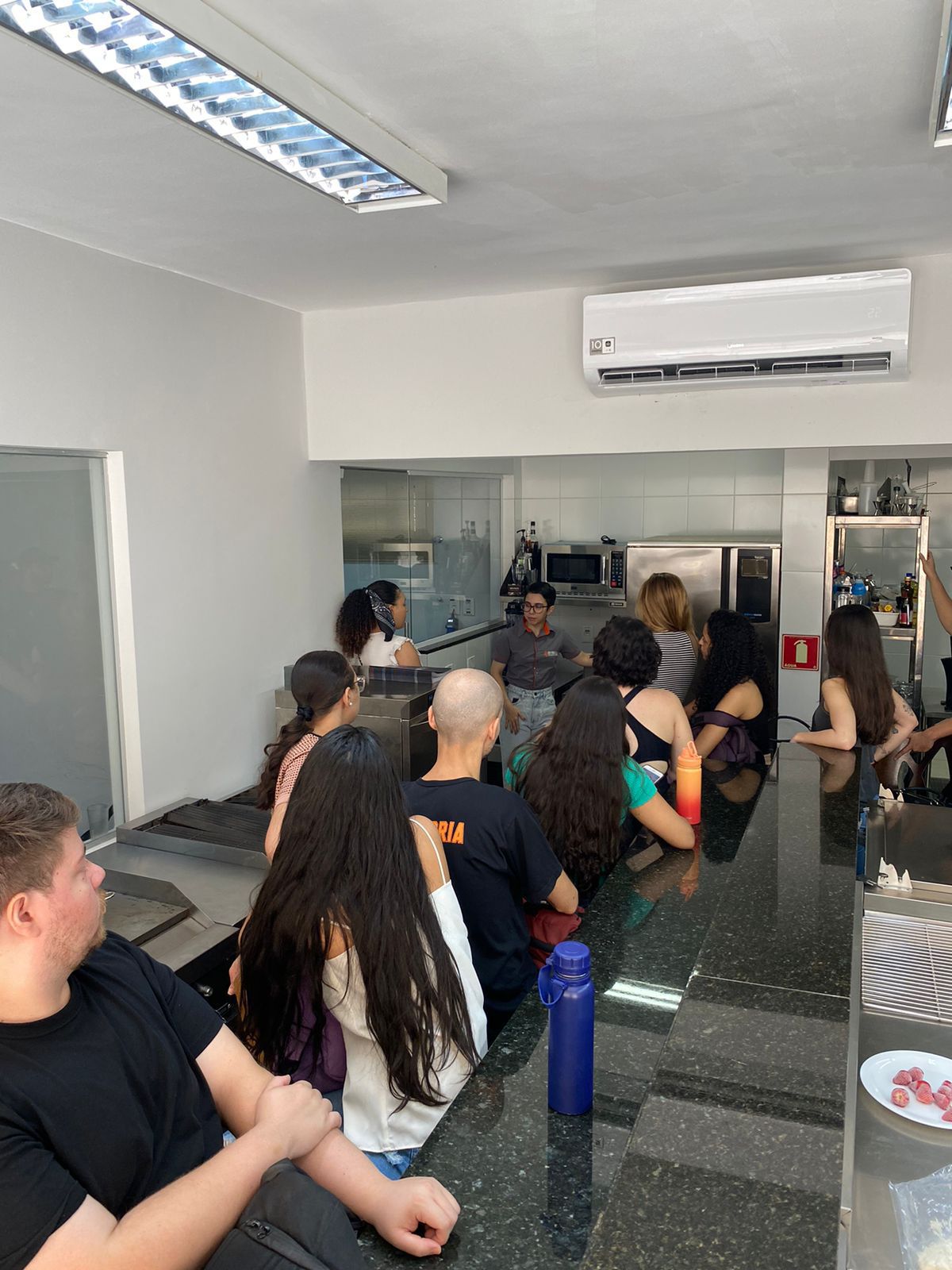 Um grupo de pessoas está sentado à mesa na cozinha.