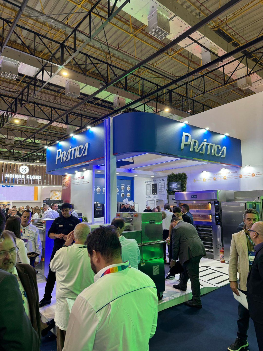 Um grupo de pessoas está em volta de um estande em uma convenção.