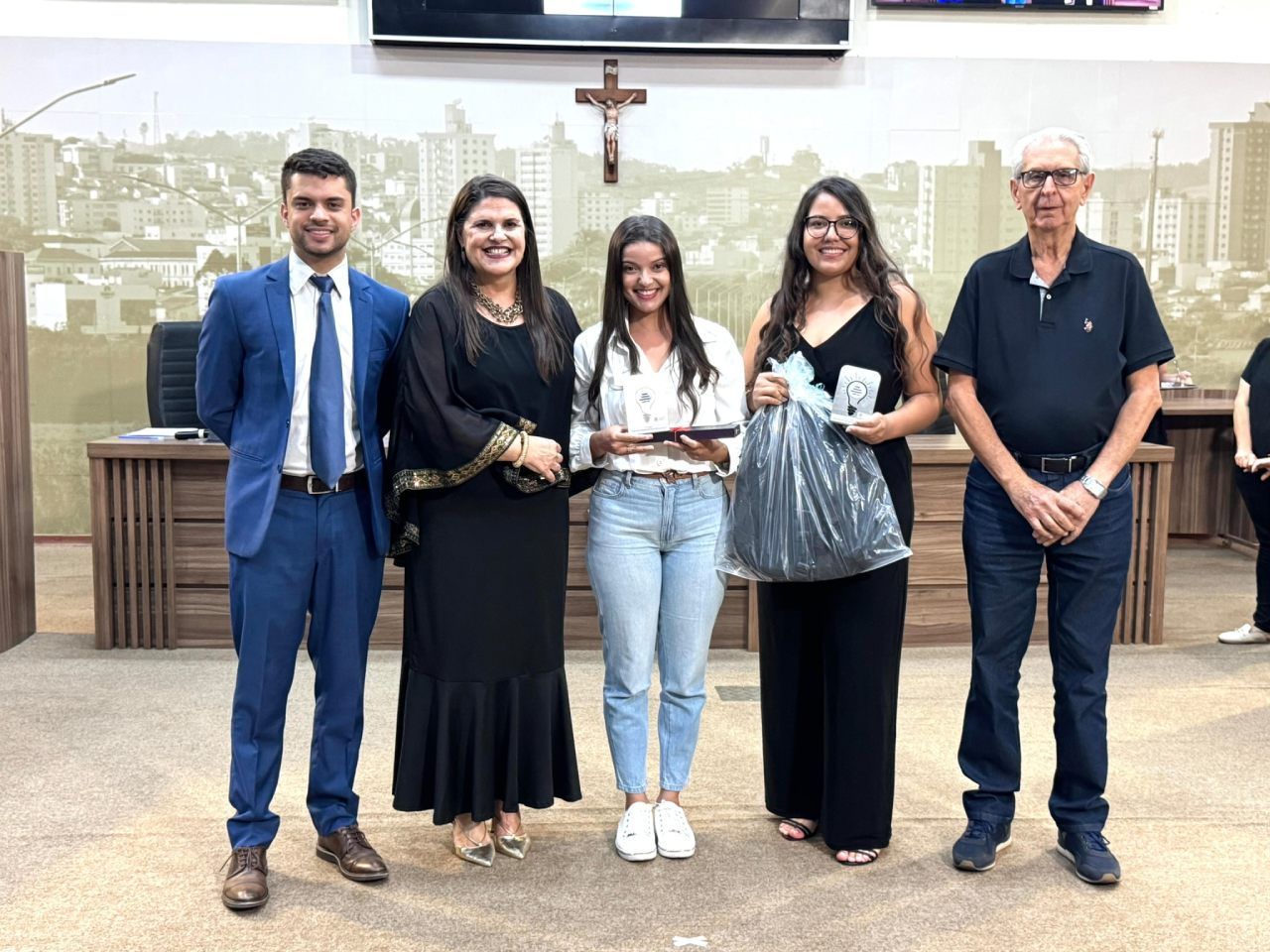 Um grupo de pessoas está de pé, uma ao lado da outra, em uma sala.