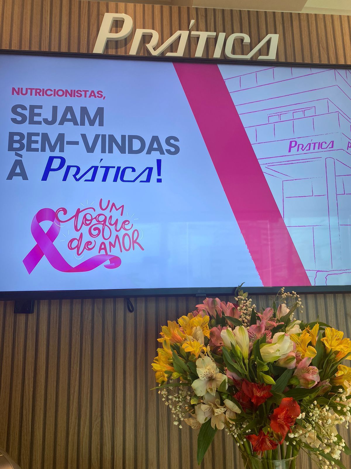 A bouquet of flowers sits in front of a sign that says