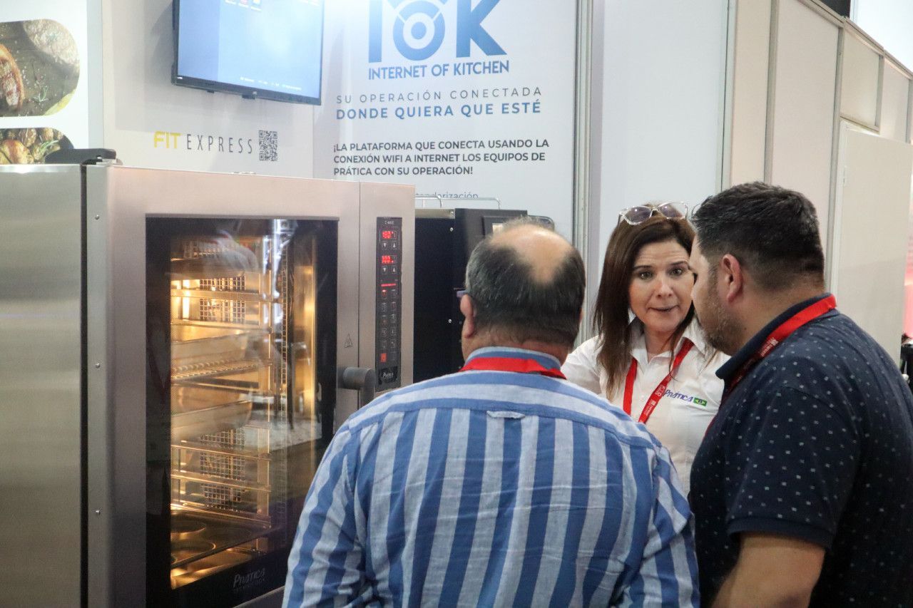 Um grupo de pessoas está em pé em frente a um grande forno.