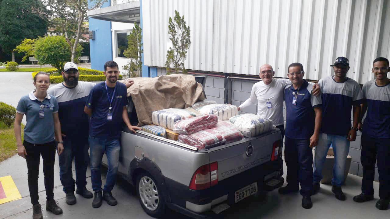 Um grupo de pessoas está posando para uma foto na frente de um caminhão.