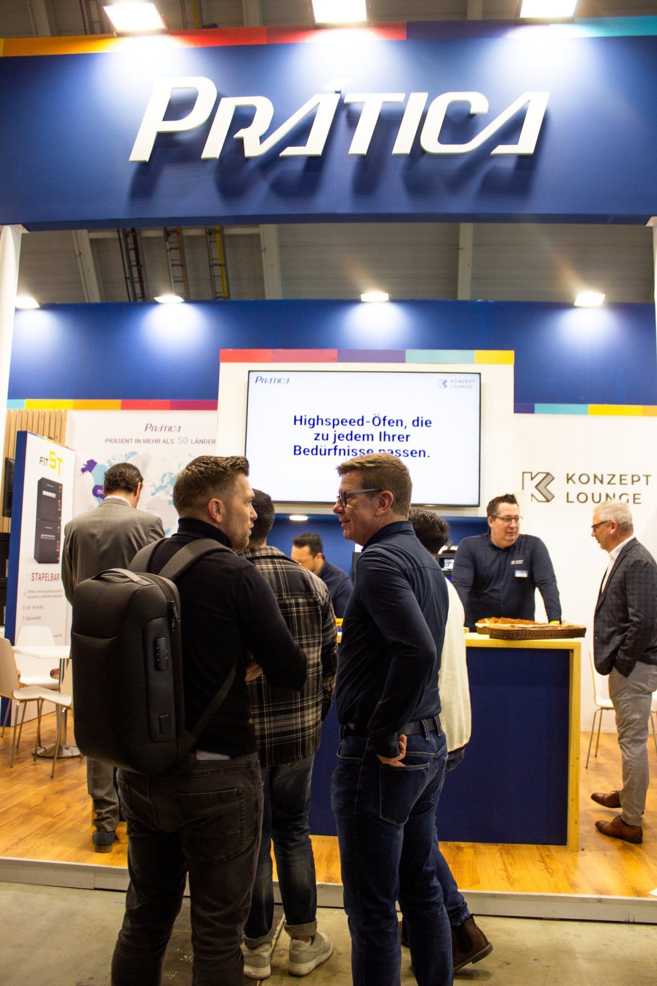 Um grupo de pessoas está em frente a uma cabine de prática.