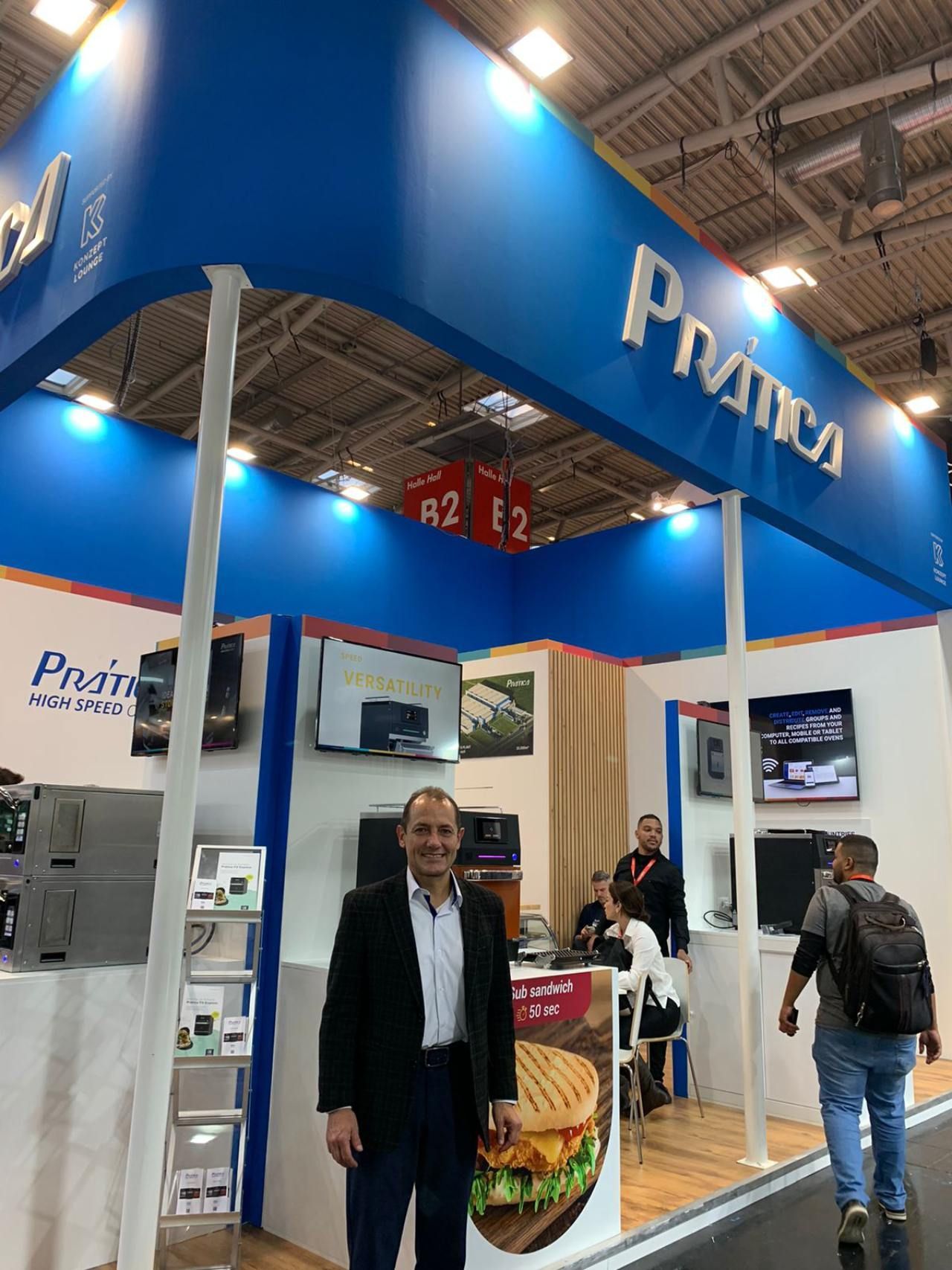 Um homem está em frente a uma placa azul que diz prima