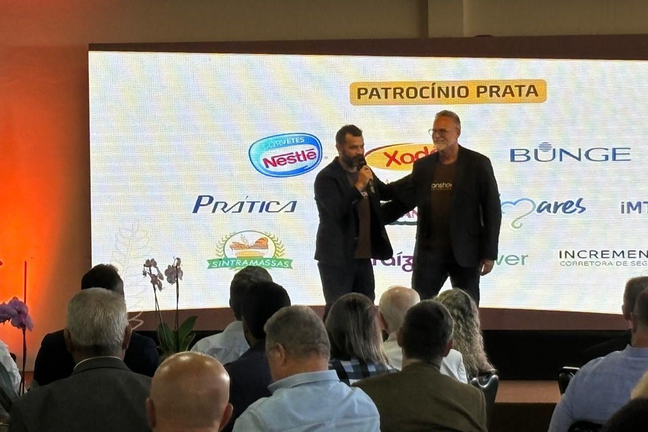 Um grupo de pessoas está sentado em frente a uma tela grande.