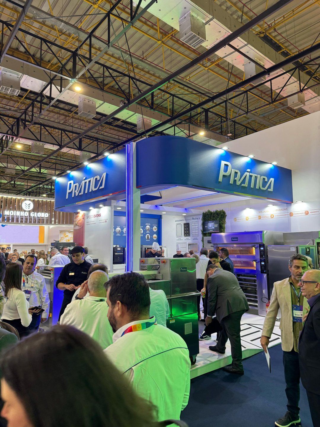 Um grupo de pessoas está em volta de um estande em uma convenção.