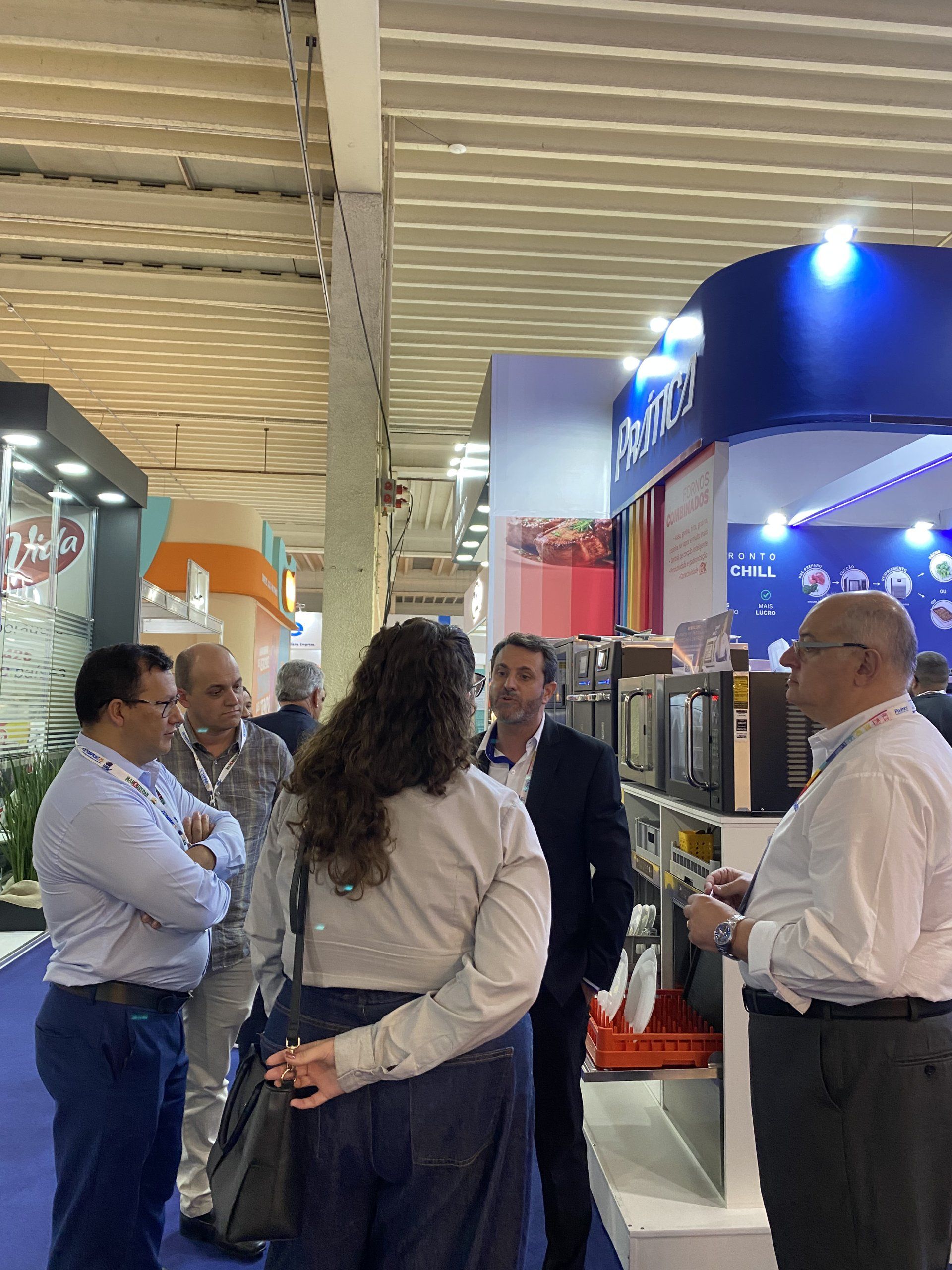 Um grupo de pessoas está em uma sala conversando entre si.