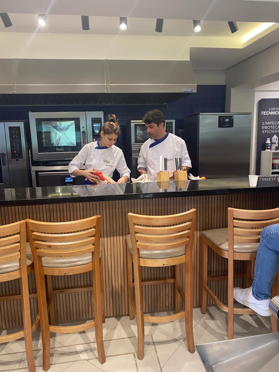 Um homem e uma mulher estão de pé em um balcão de uma cozinha.