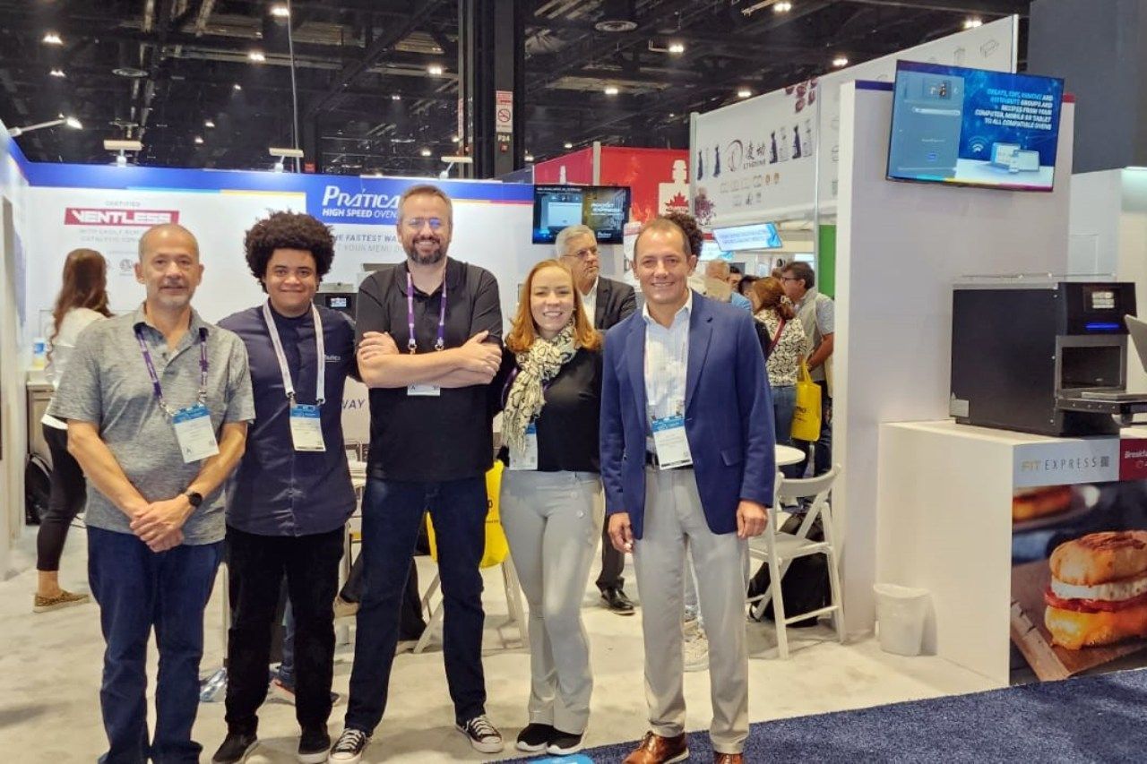 Um grupo de pessoas está posando para uma foto em uma convenção.