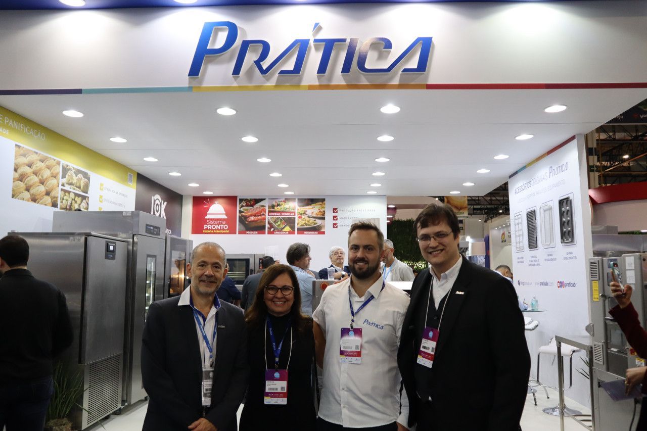 Um grupo de pessoas está posando para uma foto em frente a um estande de prática.