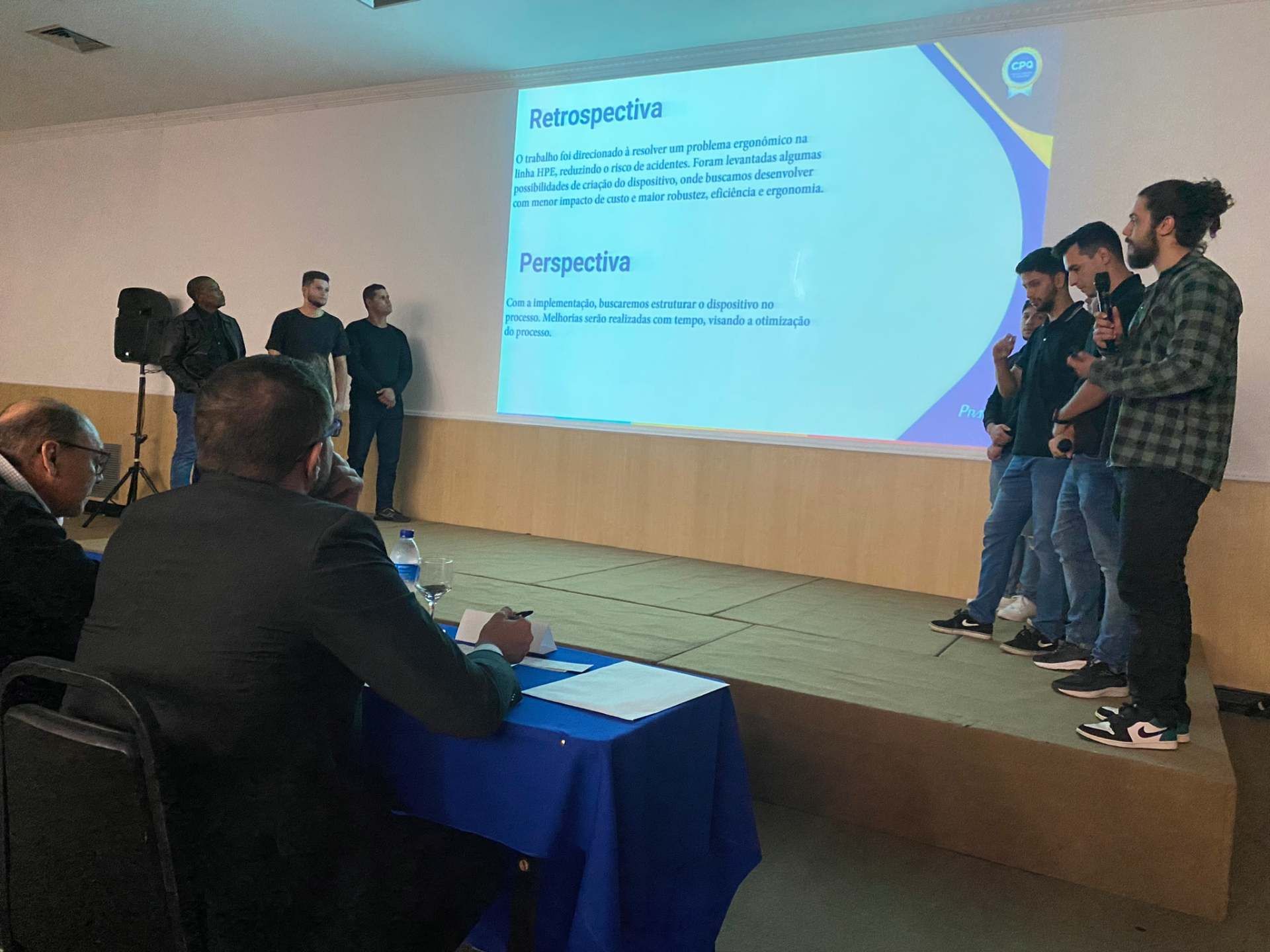 Um grupo de homens está em um palco fazendo uma apresentação.