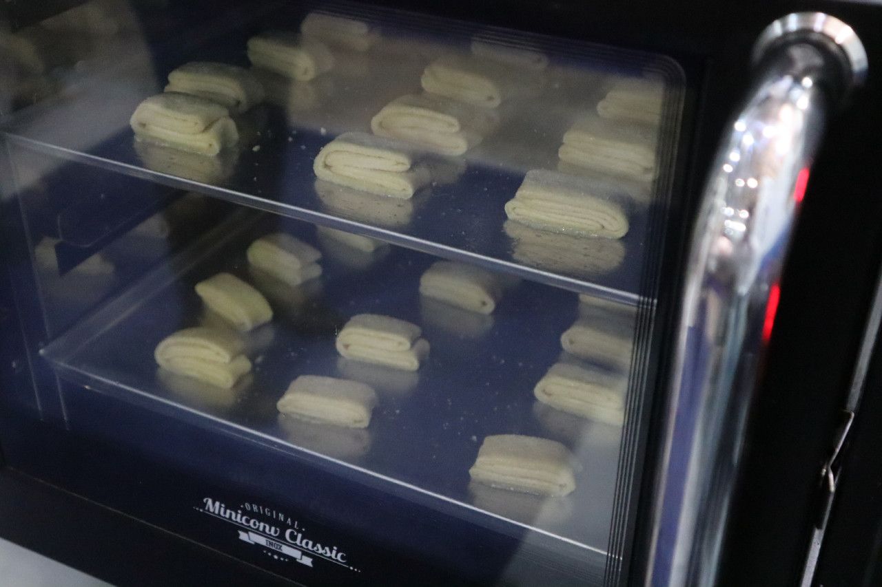 Um monte de biscoitos estão no forno.